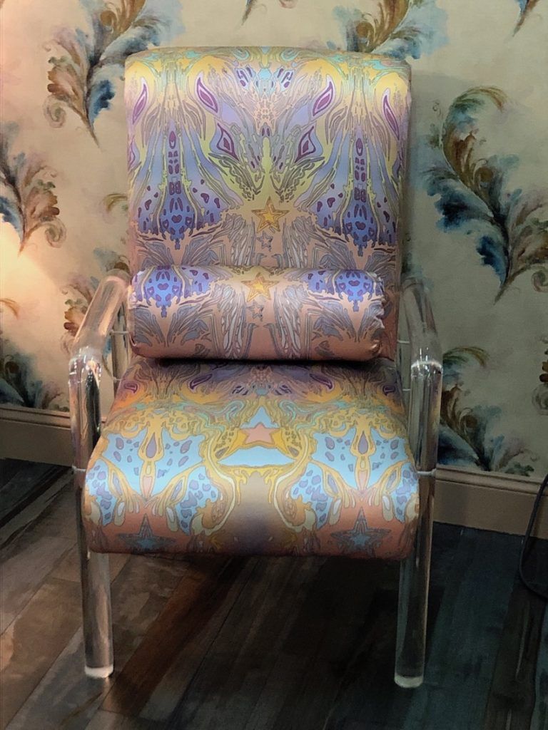 璐彩特和一个奇异的淡纺织品创建一个很女性化的椅子上。